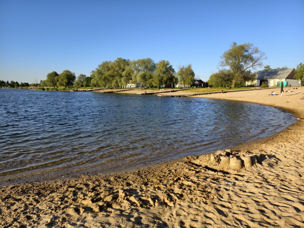 Piaszczysta plaża i łagodne zejście do wody na kąpielisku Przylasek Rusiecki w Krakowie