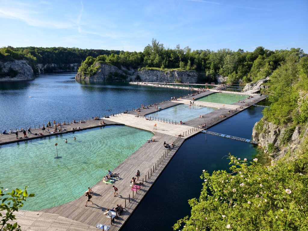 Turkusowe niecki basenowe i drewniane pomosty na kąpielisku Zakrzówek w dawnym kamieniołomie w Krakowie