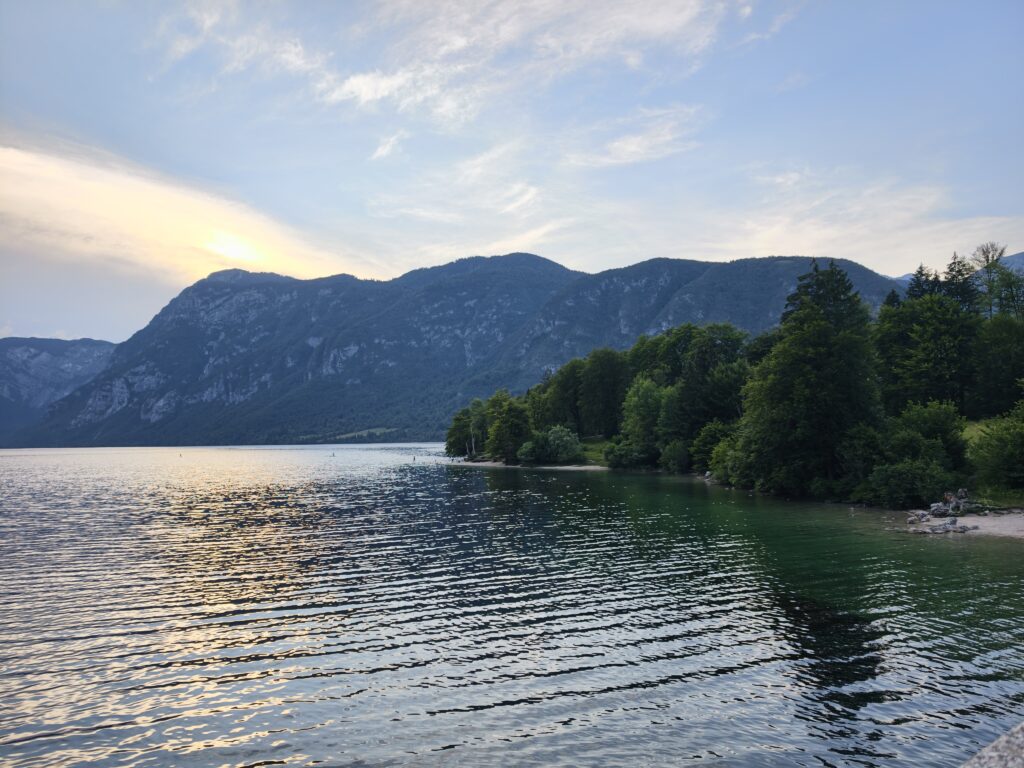 Zachód słońca nad jeziorem Bohinj z widokiem na plażę i las