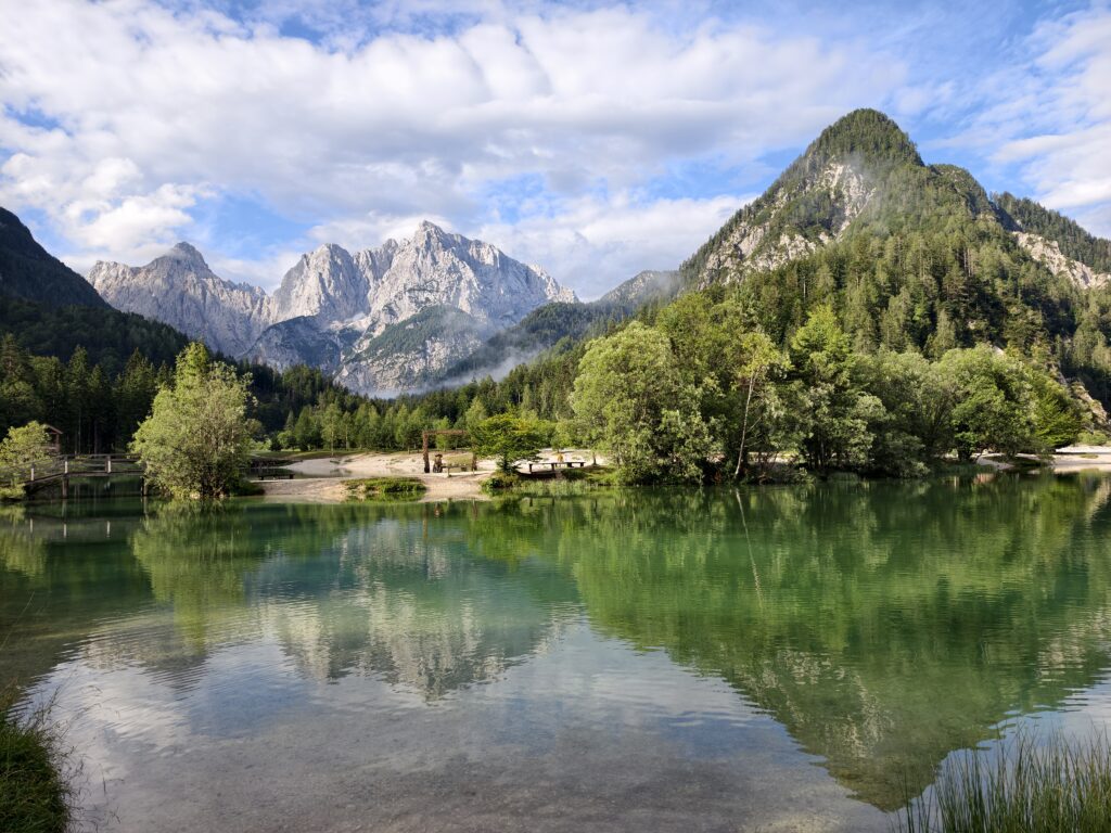 Szmaragdowa woda Jeziora Jasna w Kranjskiej Gorze z idealnym odbiciem majestatycznych szczytów Alp Julijskich.