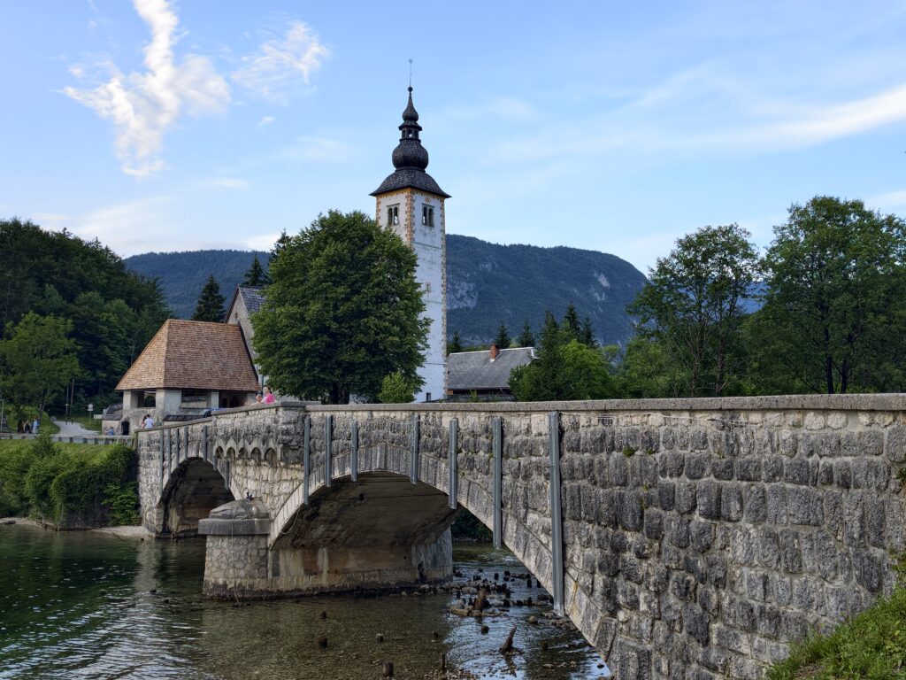 Kamienny most i wieża kościoła św. Jana Chrzciciela w Ribčev Laz nad jeziorem Bohinj