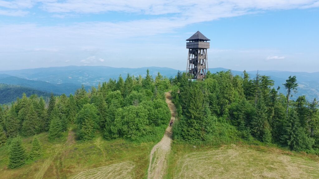 Szczyt Lubania z wieżą widokową i bazą namiotową widoczną na polanie w tle