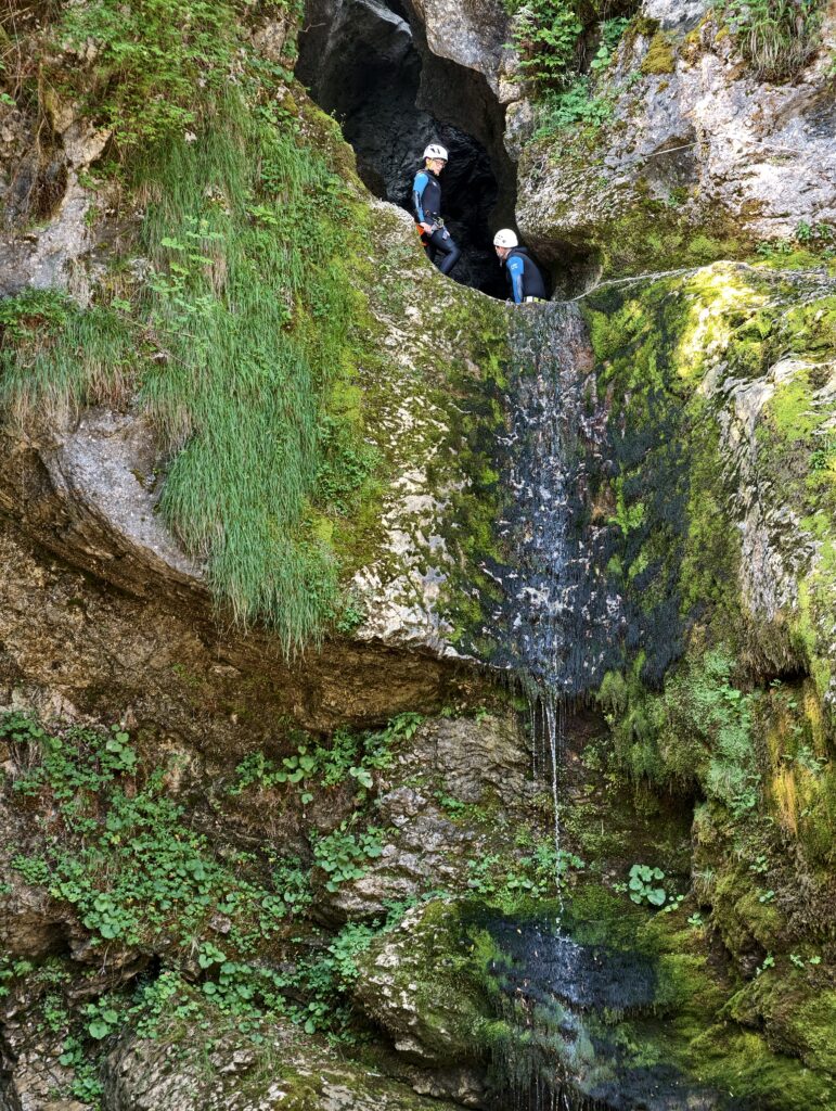 Osoby uprawiające canyoning w wąwozie nad wodospadem Grmečica