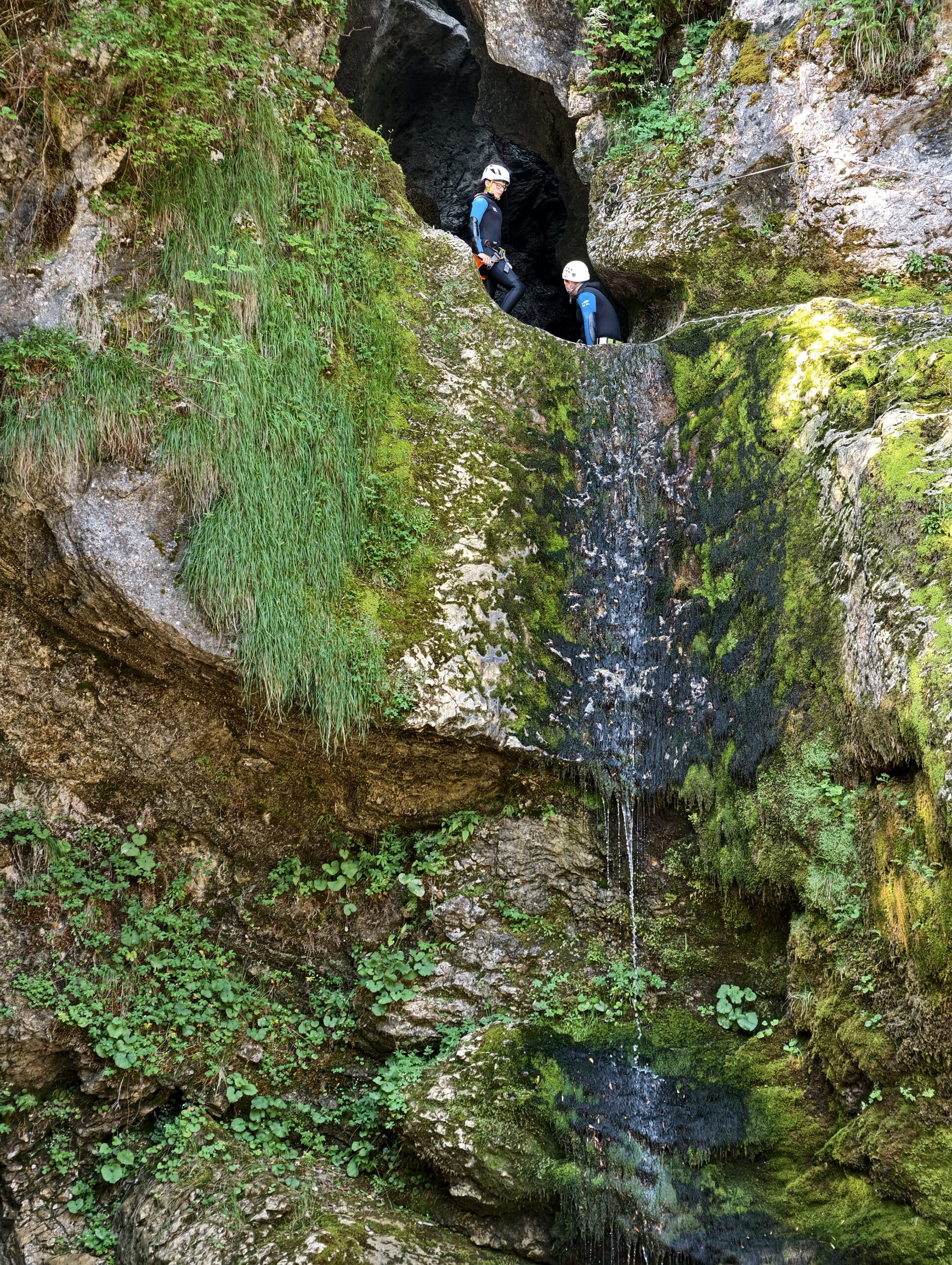Osoby uprawiające canyoning w wąwozie nad wodospadem Grmečica