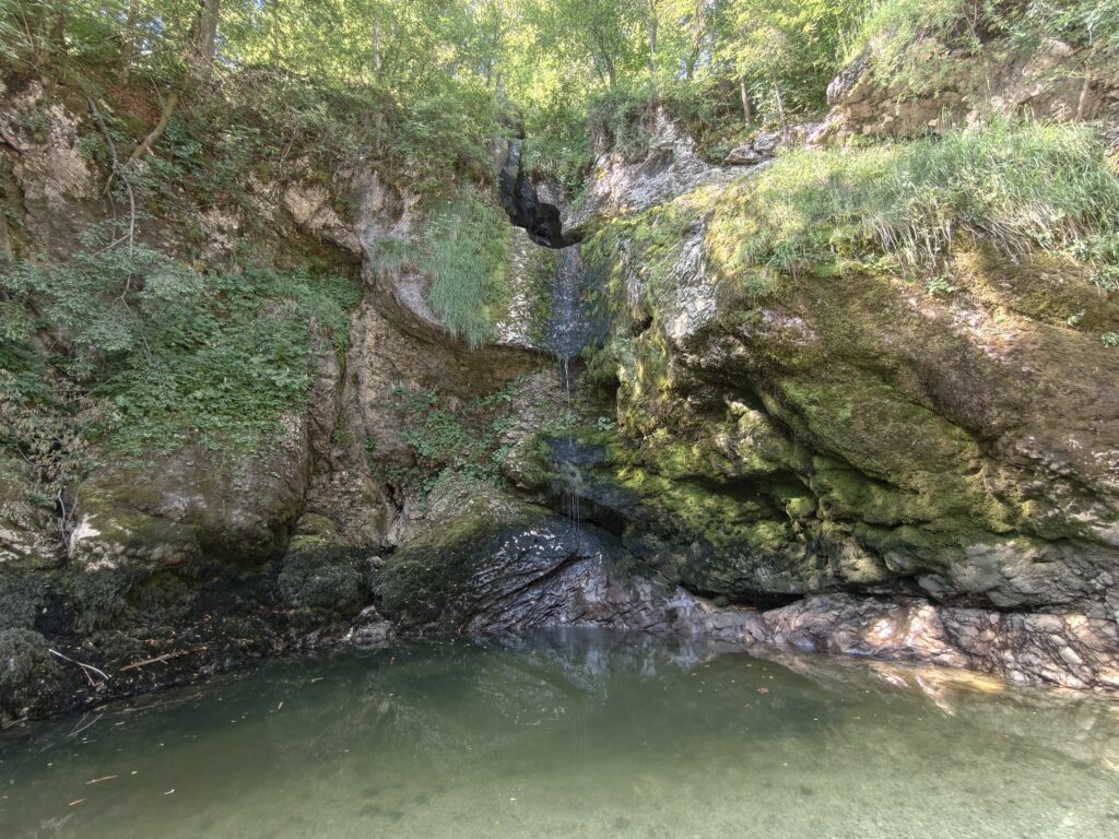 Panorama wąwozu z wodospadem Grmečica i basenem wodnym latem