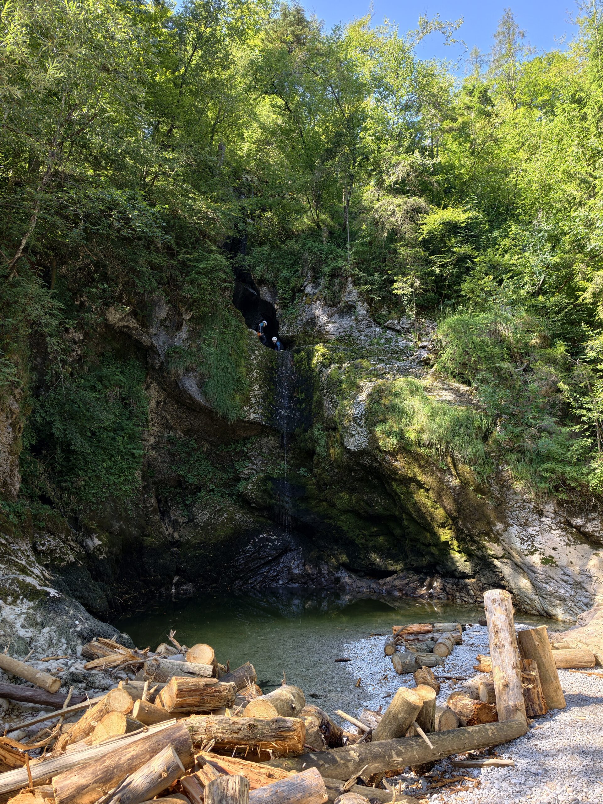 Panorama wąwozu z wodospadem Grmečica i osobami uprawiającymi canyoning