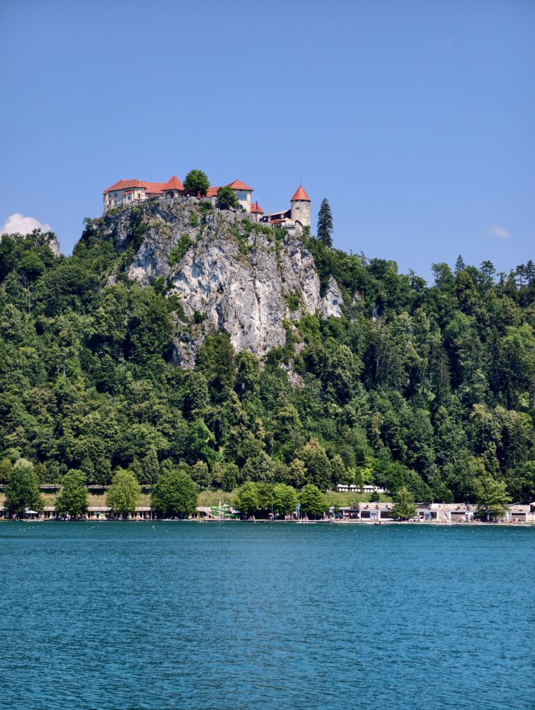 Zamek Bled na skalistym urwisku widziany z poziomu jeziora