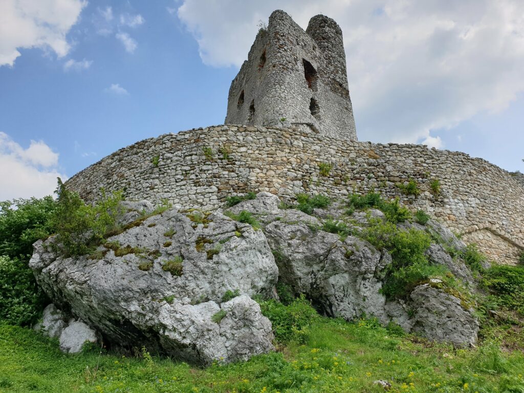 Dwie kamienne baszty zamku Mirów osadzone na naturalnym skalnym wzniesieniu