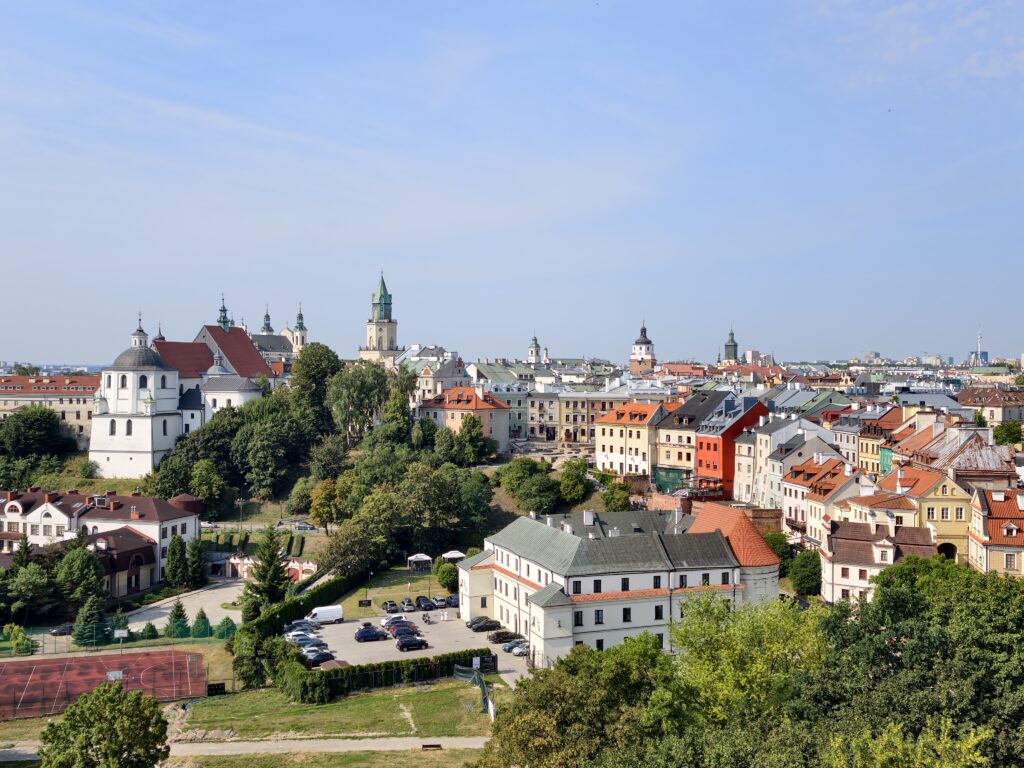 Panorama lubelskiego Starego Miasta z widoczną wieżą kościelną, kolorowymi kamienicami i dachami starówki