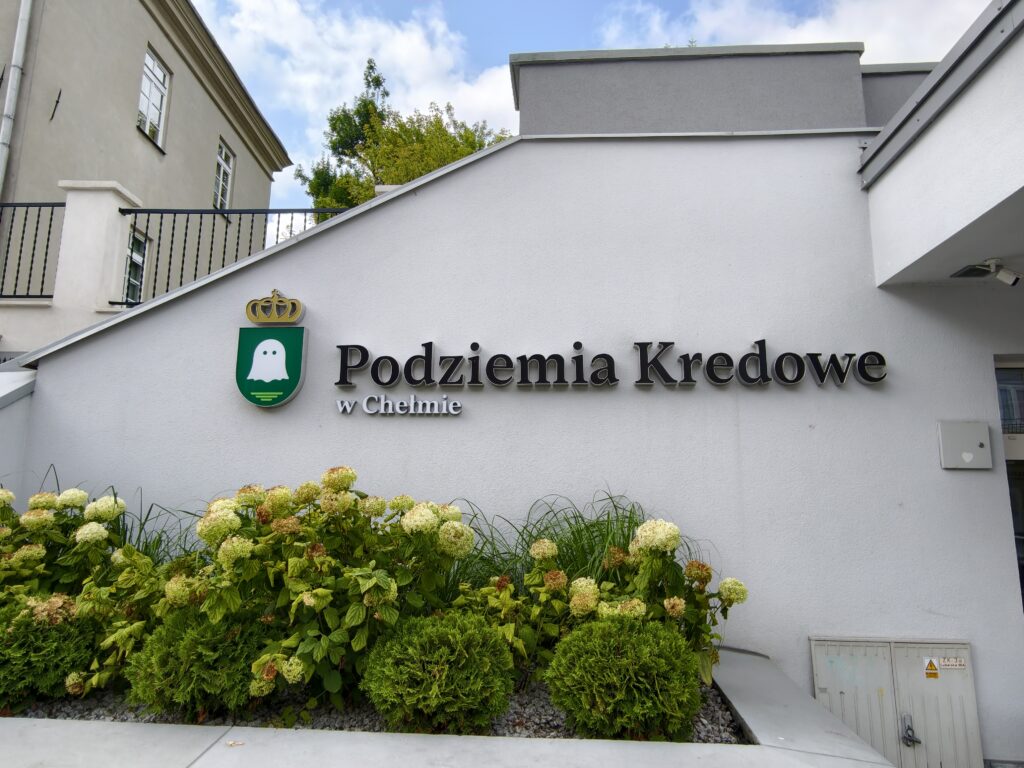 Szyld z napisem „Podziemia Kredowe w Chełmie" i herbem miasta na budynku wejściowym przy ulicy Lubelskiej