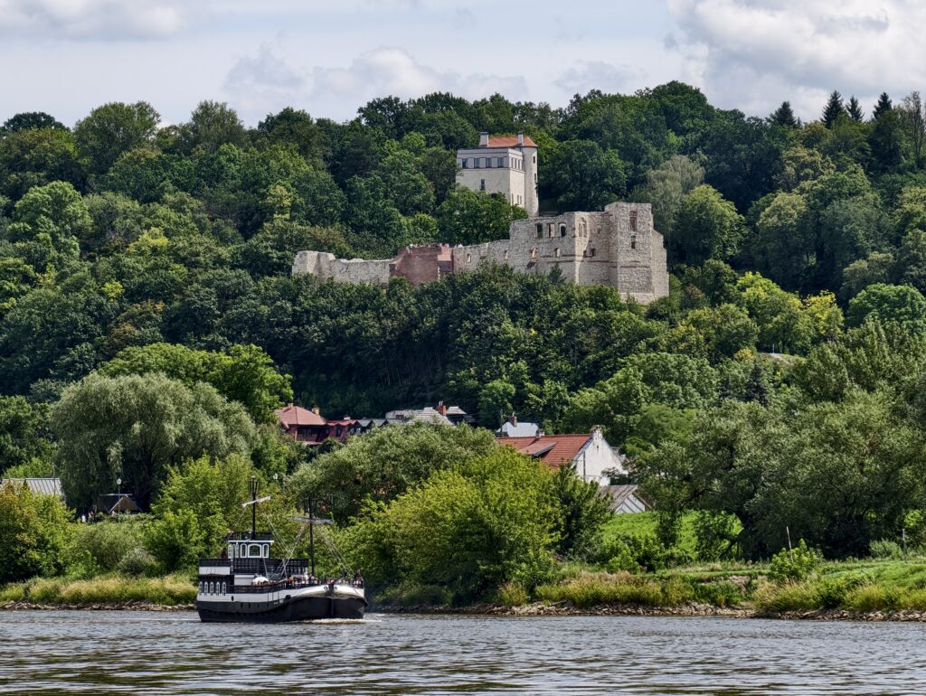 Statek wycieczkowy na Wiśle płynący pod ruinami zamku w Kazimierzu Dolnym